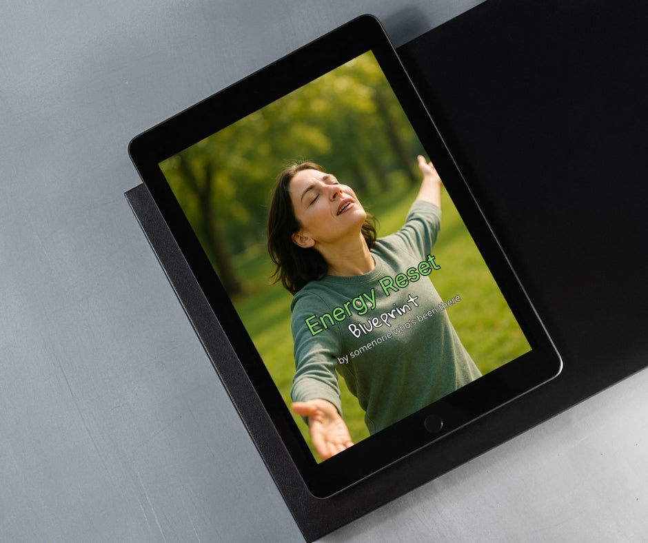 Tablet displaying a woman in nature with 'Energy Reset Blueprint' text on a gray surface
