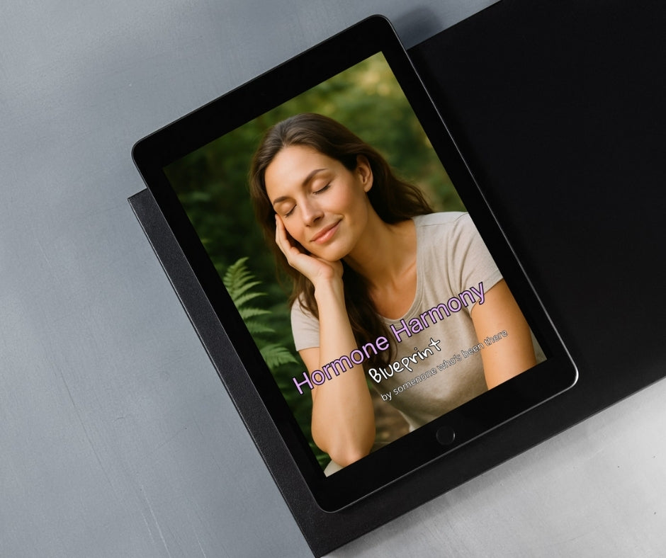 Tablet displaying a woman's face with 'Hormone Harmony Blueprint' text on a gray surface